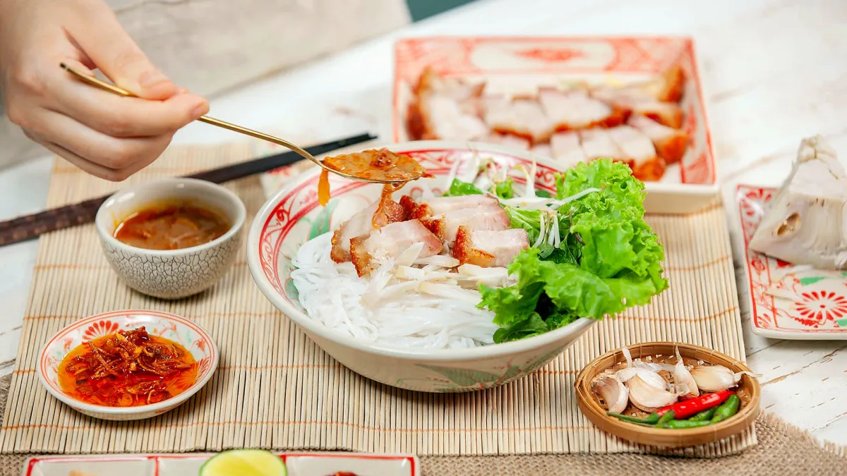 A bowl of bún mắm with roast pork, herbs and fermented anchovy sauce