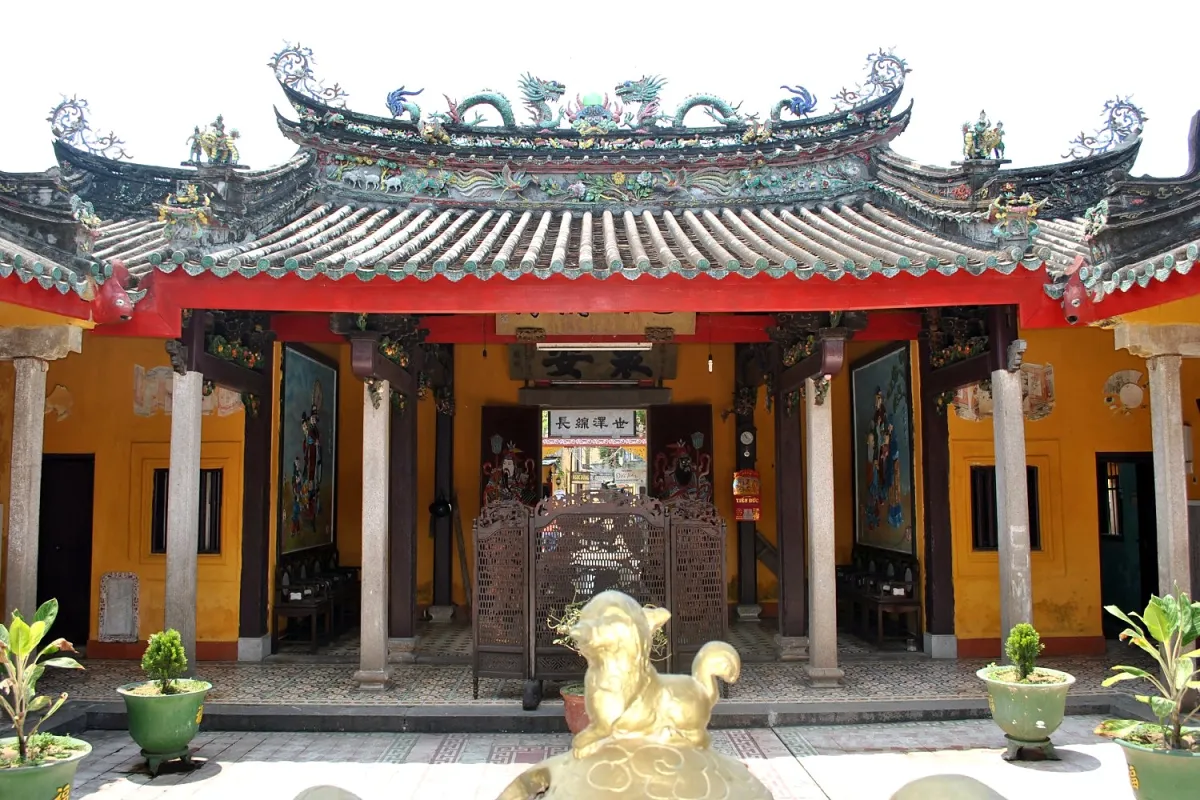 Main hall of the Chaozhou Assembly Hall seen from the courtyard, with a colorful ceramic roof ridge, stone pillars and yellow walls