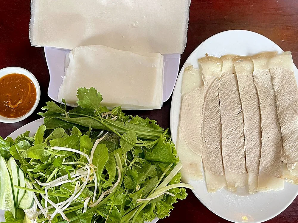 Rice paper, herbs, sliced boiled pork and anchovy dip for bánh tráng cuốn thịt heo