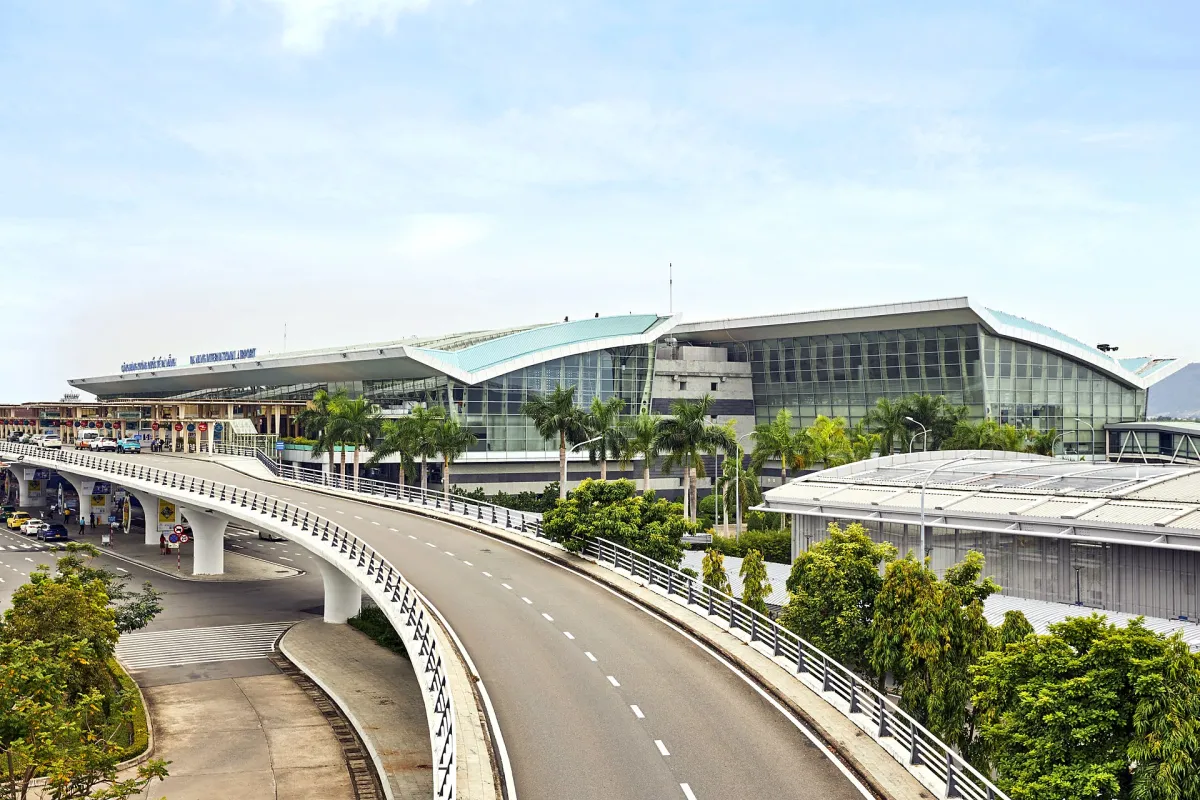The domestic terminal at Da Nang airport with its curved green roof and glass front, an elevated departures road curving up to it