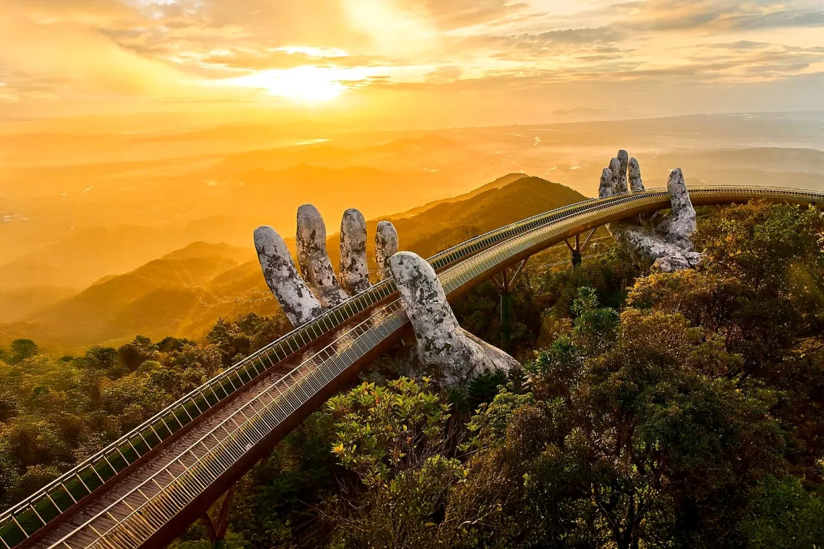 The Golden Bridge at Ba Na Hills held up by two giant hands, at sunset