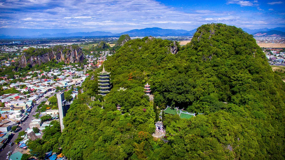 The Marble Mountains, with a pagoda tower among trees, seen from the air