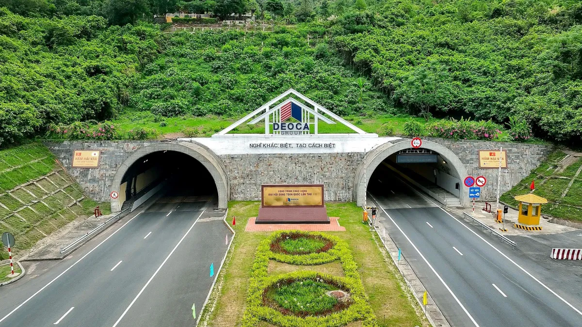 The two entrances of the Hai Van road tunnel at the foot of a green mountain, seen from above