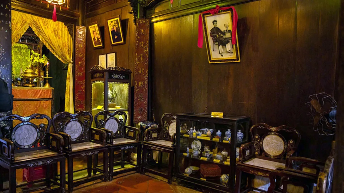 The wooden interior of Tan Ky old house in Hoi An, with carved chairs and an altar
