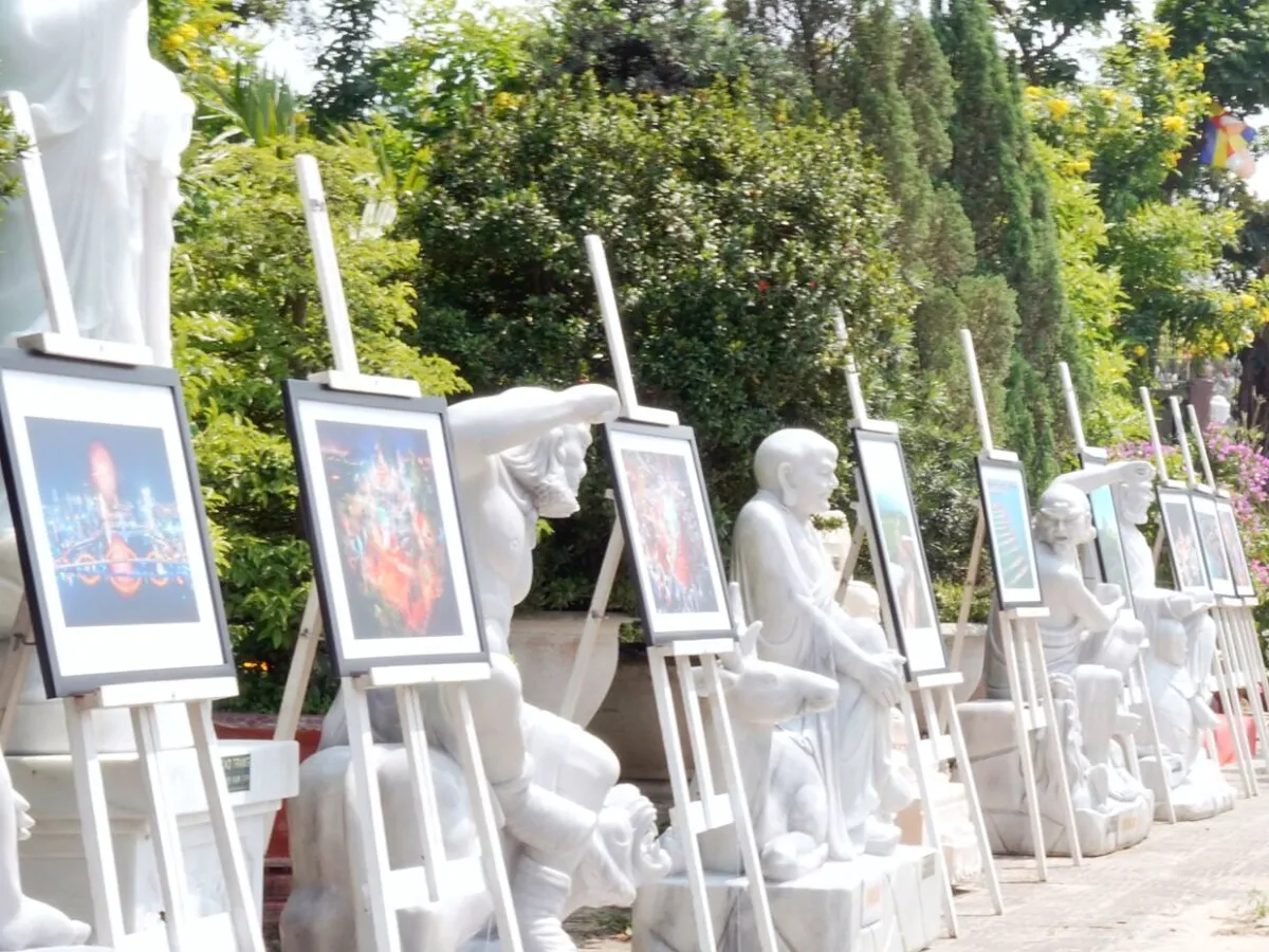 White marble statues and paintings on display along a path below the Marble Mountains